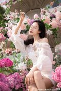 【时尚一点】小姐姐身穿白色连衣裙，慵懒地躺坐在紫色花海中，光影照射下的美女更加的诱