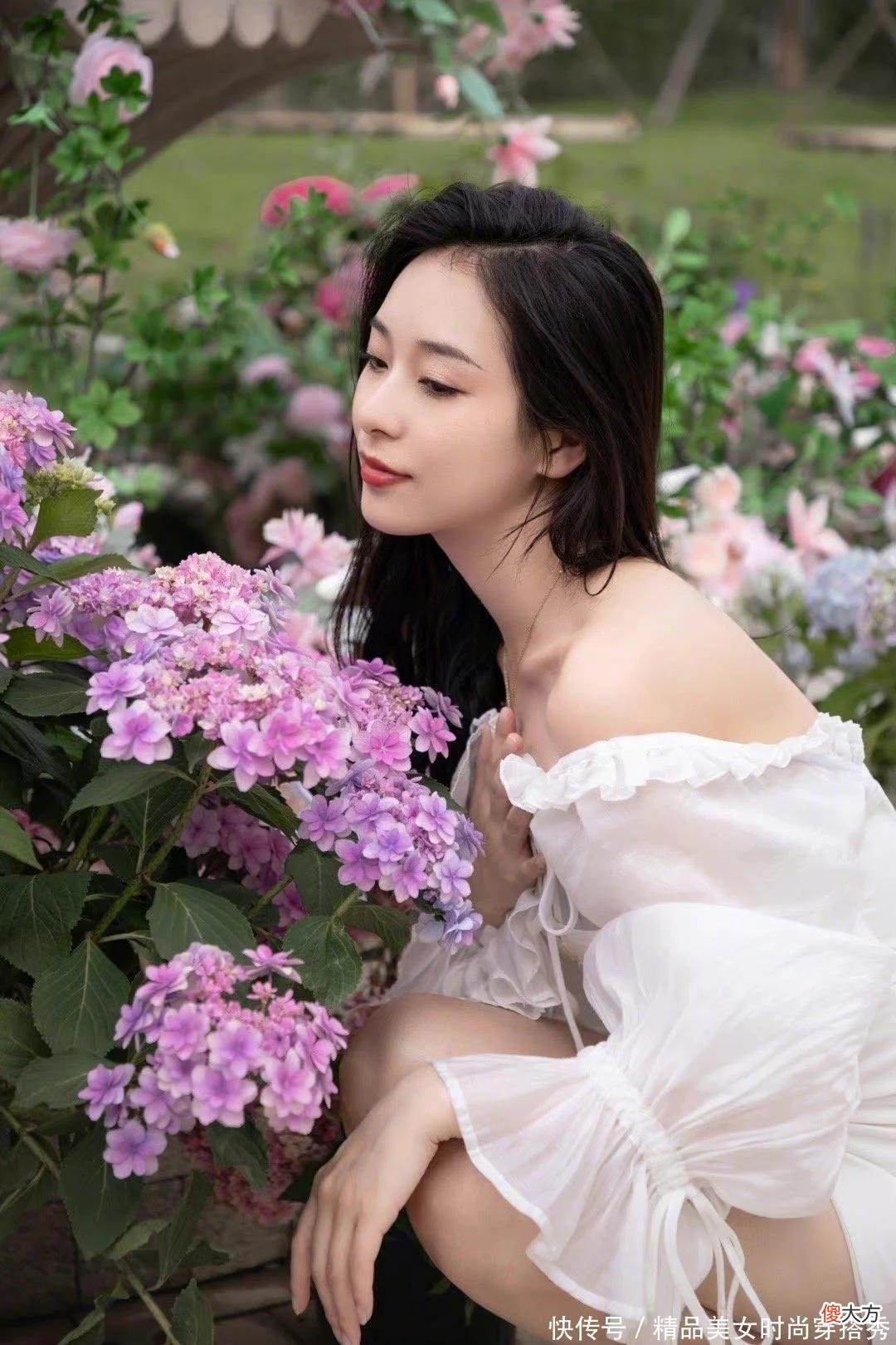【时尚一点】小姐姐身穿白色连衣裙，慵懒地躺坐在紫色花海中，光影照射下的美女更加的诱人